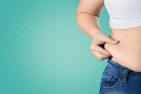 Image of woman pinching her love handles to show weight gain Westminster